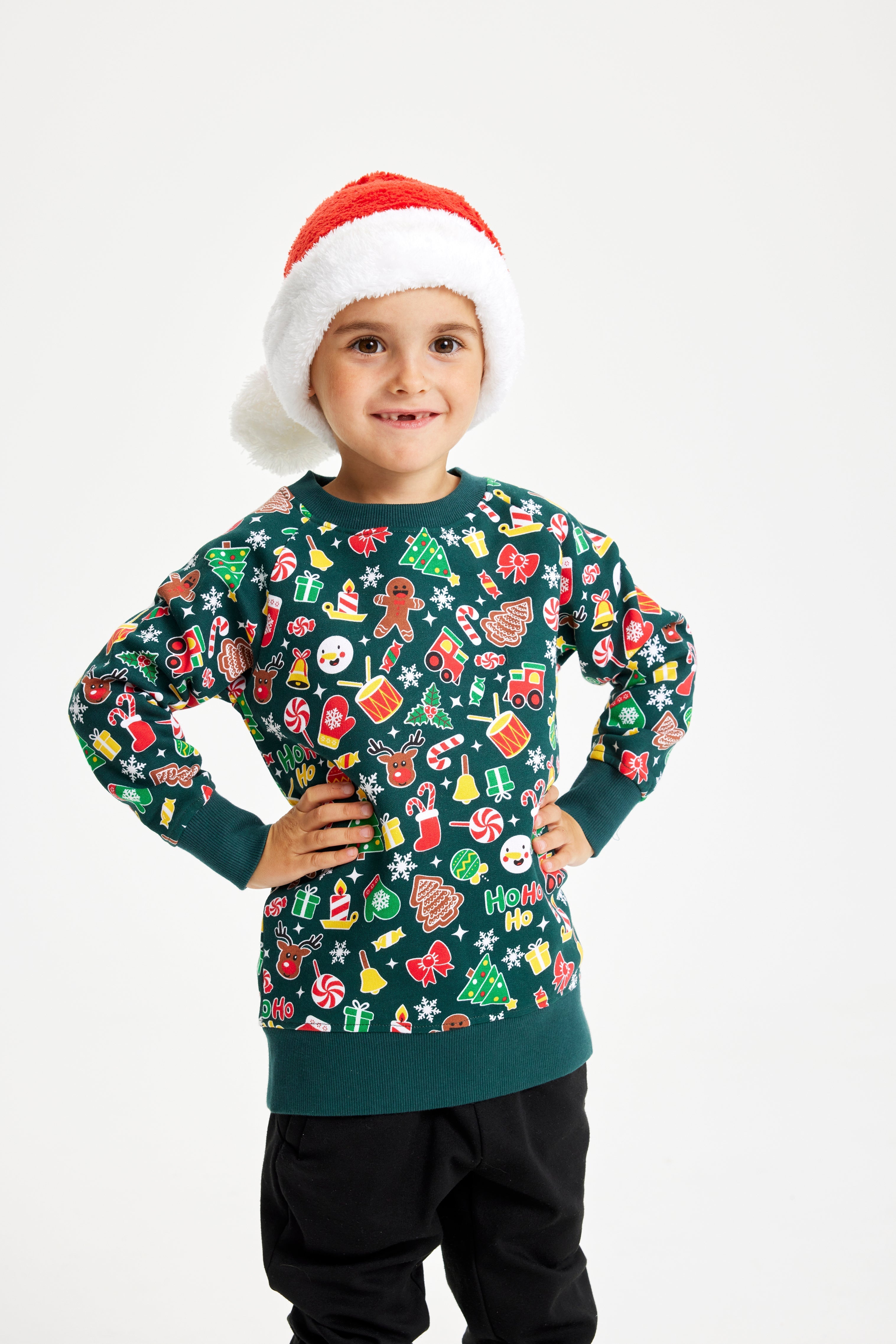 Un bambino che indossa un maglione natalizio verde.